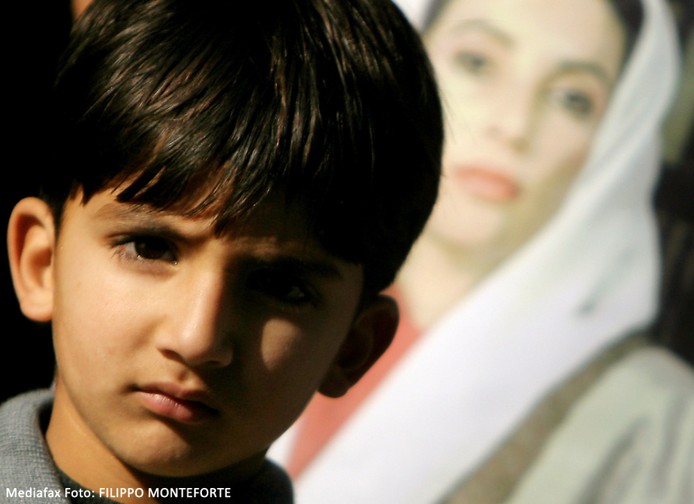 Un băieţel pakistanez, lângă porterul lui Benazir Bhutto, asasinată joi. Pakistan, 28 decembrie 2007. 
