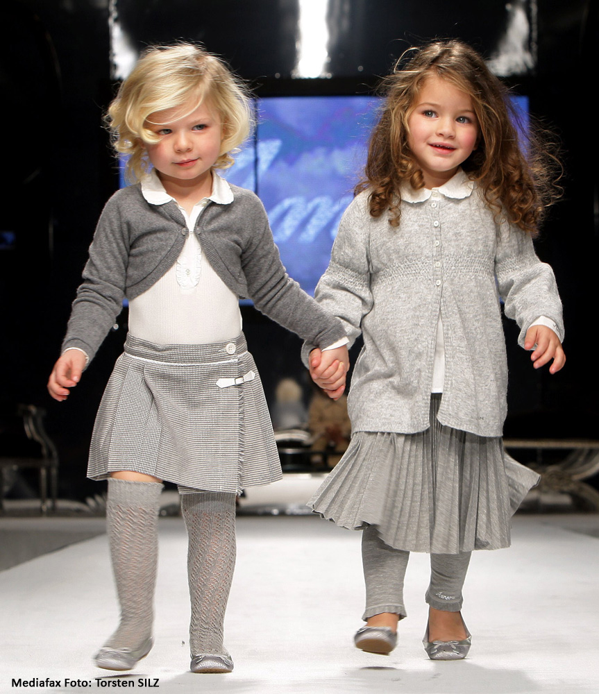 Două fetiţe prezintă articole de îmbrăcăminte din colecţia toamnă-iarnă 2008/2009. Festivalul modei pentru copii 