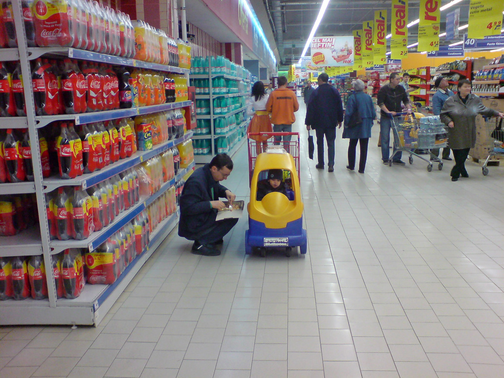 Tată şi fiu iau masa în supermarket. Foto: Corneliu ACASANDRE