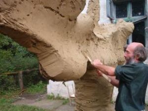Sculptorul Mircea Dăneasă realizând modelajul în lut