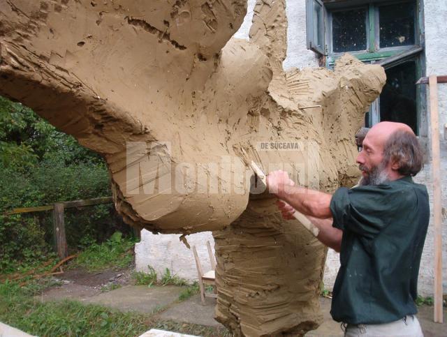 Sculptorul Mircea Dăneasă realizând modelajul în lut