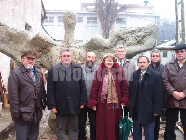 Membrii comisiei de recepţie împreună cu sculptorul, lângă monumentul realizat din argilă