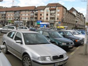 Zeci de spaţii de parcare sunt ocupate de maşini care au afişate pe ele anunţuri de vânzare