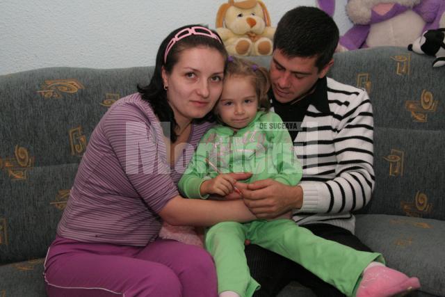 Micuţa Claudia, în braţele părinţilor săi, Valentina şi Victor Timinger