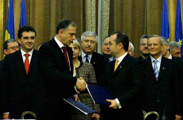 Presedintele PSD, Mircea Geoana (S), dă mâna cu preşedintele PD-L, Emil Boc (D), după semnarea Parteneriatului PD-L - PSD pentru România. Foto: MEDIAFAX