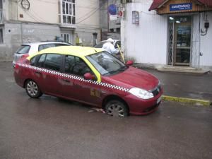 Capcanele străzii: Taxi căzut într-o groapă căscată în asfalt, în centrul Sucevei