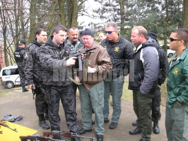 Şeful DPIR Suceava, comisarul Vasile Maciuc, le arată americanilor armele din dotarea poliţiei sucevene