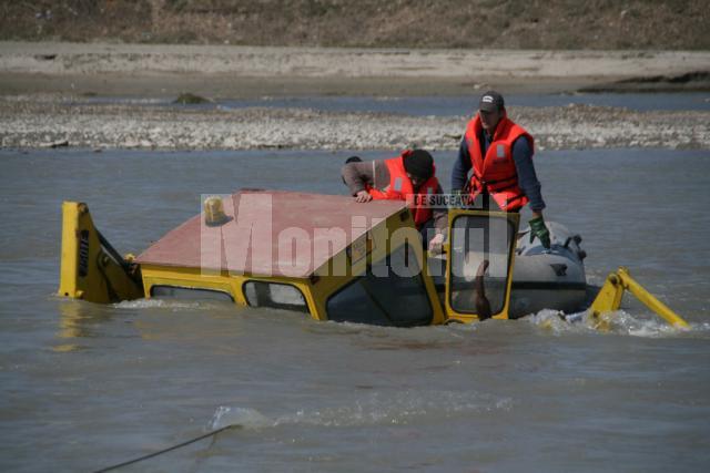 La un pas de tragedie: Au rămas în mijlocul râului Suceava după ce au vrut să-l treacă cu excavatorul