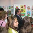 Gheorghe Flutur înconjurat de copii privind cu încântare desenele