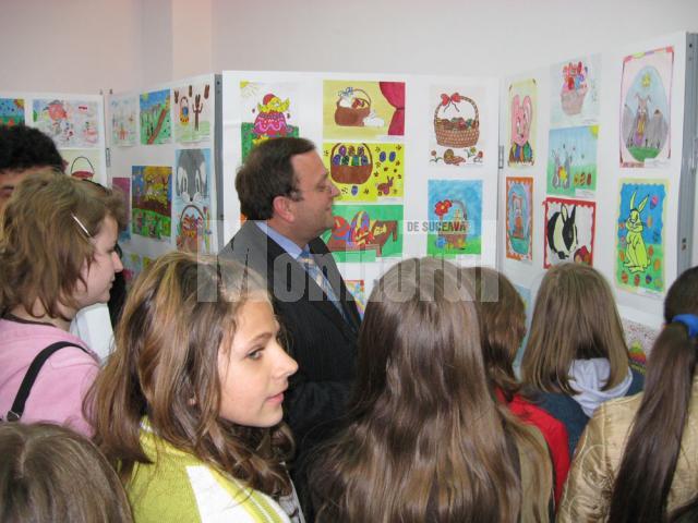 Gheorghe Flutur înconjurat de copii privind cu încântare desenele