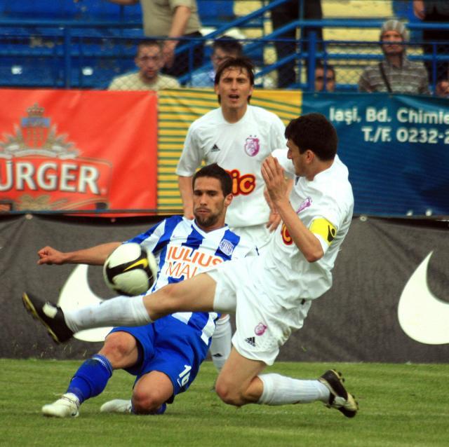 Nuno Viveiros (jos), de la Poli Iaşi, se luptă pentru balon cu doi adversari, în meciul cu FC Argeş. Foto: MEDIAFAX