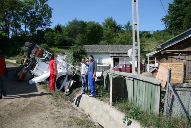 Drum denivelat: Familie în pericol după ce o betonieră a „plonjat” în faţa casei