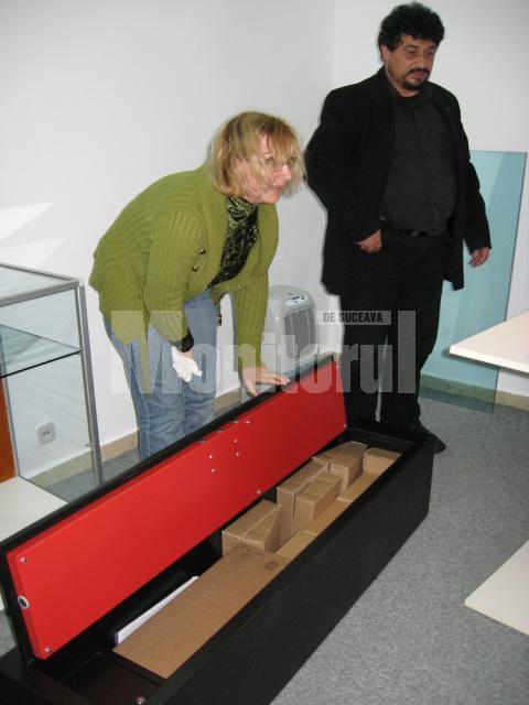 Directorul Emil Ursu si muzeograful Monica Dejan deschid seiful cu care au fost transportate piesele de patrimoniu