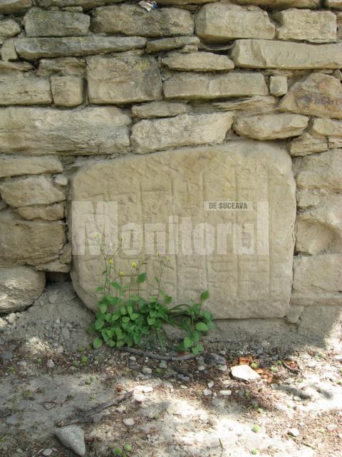 Piatra cu semne incizate incastrata in zid