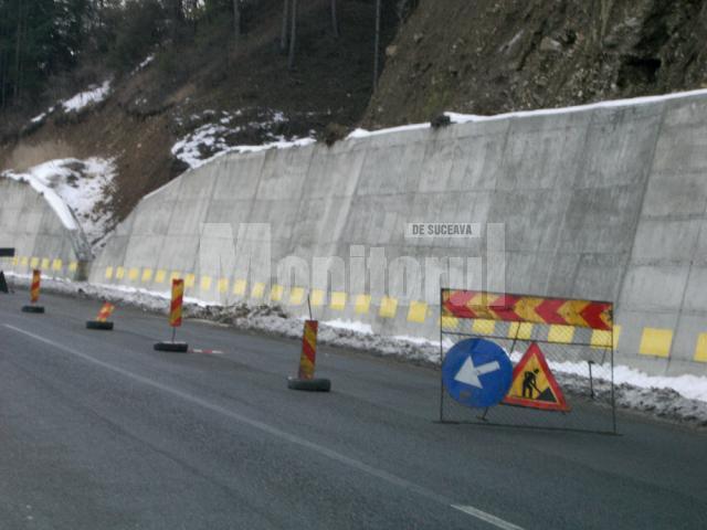 De deasupra zidului de beton ridicat pentru consolidarea dealului de lângă şosea au început să alunece pământ şi pietriş