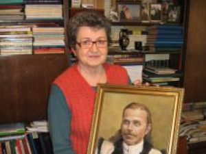 Elena Ienache cu portretul străbunicului Ioan Dugan-Opaiţ şi un vechi album de familie