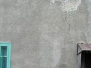 Ioana Răstoacă arată cu tristeţe către una din crăpaturile apărute în zidul casei sale