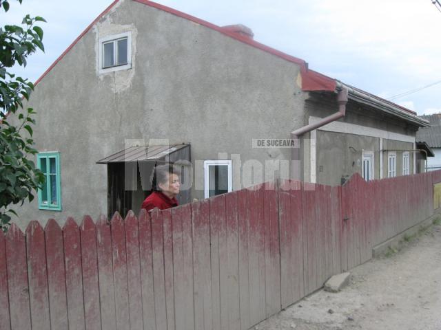 Gardul si casa Ioanei Răstoacă, acoperite de noroiul aruncat din gropi de rotile maşinilor
