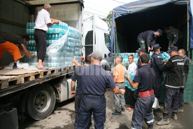 Jandarmi descarcand apa plata pentru sinistrati