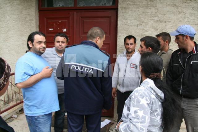 Secretarul, consilierul juridic, poliţistul din sat şi romii nemulţumiţi, în faţa sediului unde sunt depozitate ajutoarele