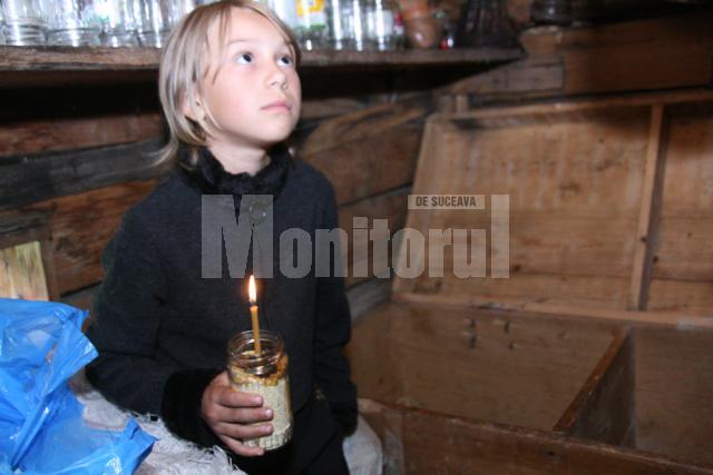 Irina, micuţa de zece ani, cu o lumânare lângă lada în care au murit fraţii ei
