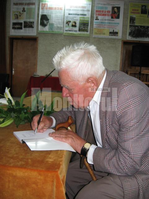 Scriitorul George Ungureanu acordând autografe cititorilor
