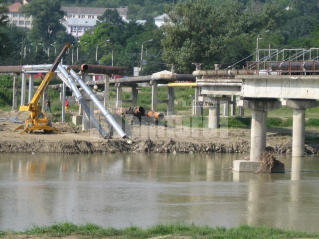 Conductele de apă caldă şi apă rece care traversau râul Suceava pe podul tehnic rupt de ape la inundaţiile din luna iulie au fost deja demontate parţial
