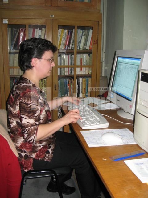 Bibliotecara Margareta Scutaru, lucrând la evidenţa computerizată a fondului de carte al bibliotecii