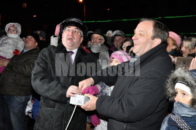 Primarul Ion Lungu, preşedintele CJ, Gheorghe Flutur, împreună cu o fetiţă din public au aprins luminile din bradul din centrul Sucevei