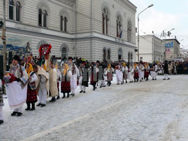 Pe strada principală din municipiu, peste 600 de urători şi mascaţi invitaţi la festival au făcut o paradă