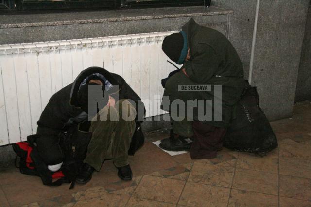 Oameni ai străzii ghemuiţi lângă calorifere, în Gara Burdujeni