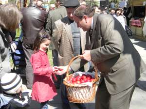Preşedintele CJ Suceava, Gheorghe Flutur, ajutat de angajaţi ai acestei instituţii au împărţit spectatorilor câte un ou roşu şi o felie de cozonac