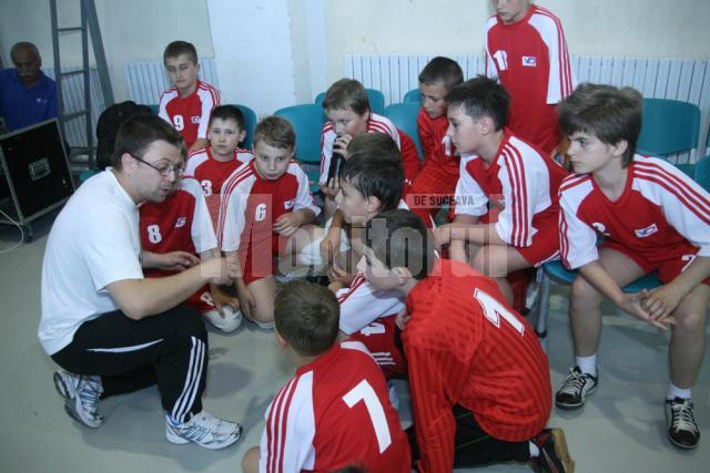 Antrenorul Răzvan Bernicu le explică micilor săi elevi tactica de joc