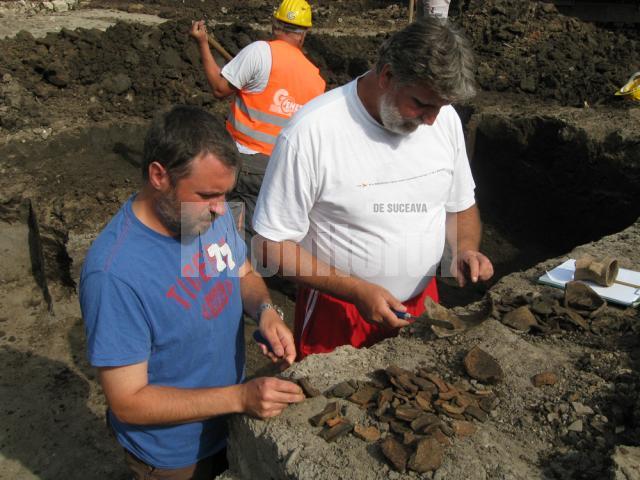 Arheologii Sorin Dejan şi Florin Hău şi câteva fragmente de ceramică descoperite