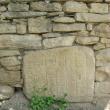 Piatră cu semne incizate încastrată în zid