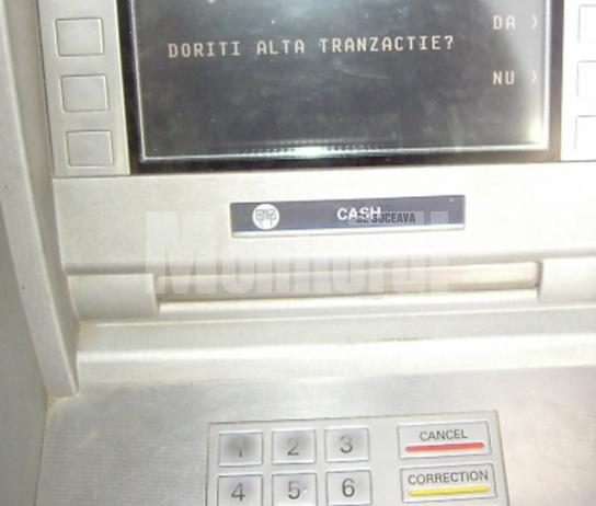 Indivizii au lipit în faţa fantei de eliberare a numerarului de la bancomat un dispozitiv care bloca banii