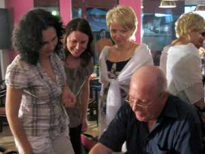 Ion Drăguşanul oferind cărţi cu autograf cititorilor
