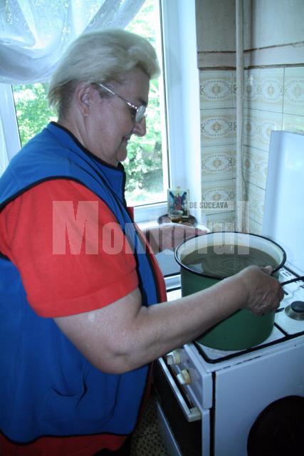 Maria Duca încălzeşte zilnic apa pentru nepotul venit în vizită la Suceava