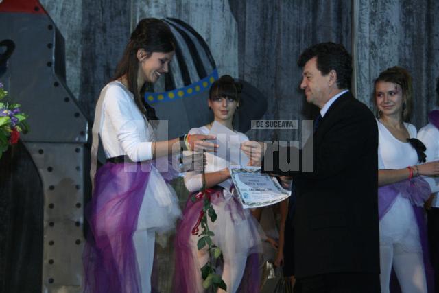 Directorul Colegiului Spiru Haret, Virginel Iordache, îi înmânează titlul de Miss Boboc elevei Elena Valentina Macoveiciuc