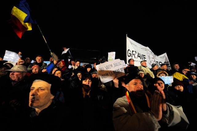 Persoane din  Piaţa Universităţii strigă lozinci contra preşedintelui Traian Basescu şi în favoarea alegerilor anticipate. Foto: MEDIAFAX