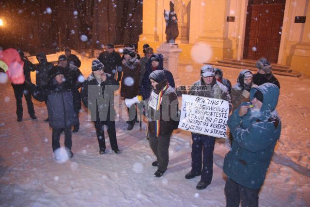 Cei aproximativ două zeci de protestatari au avut mesaje adaptate la ninsoarea şi frigul de afară