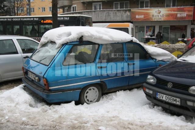 Maşini cu roţile afundate în zăpadă