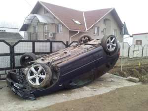 Maşina răsturnată în faţa unei case din Plopeni