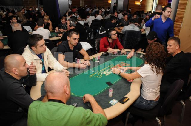 Eusebiu Jalba, în centrul imaginii, în tricou negru cu mânecile scurte, e concentrat la maxim la masa de joc