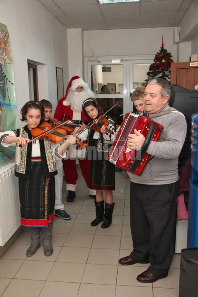 Grupul vocal-instrumental „Mugurelul” din Şcheia, însoţit de Moş Crăciun