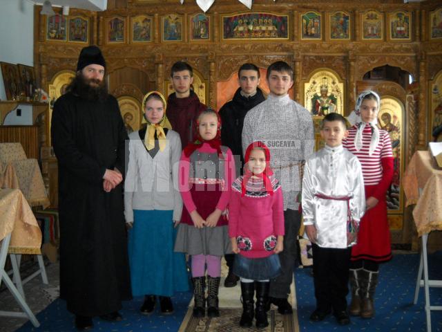 Copiii care se pregătesc de colindat, alături de preotul Ştefan Andrian