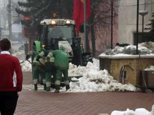 Mormanele de zăpadă de pe străzi şi trotuare sunt duse pe terenuri virane