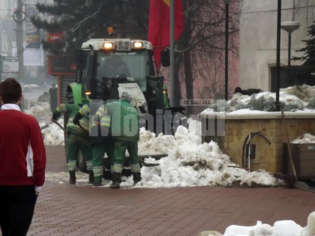 Mormanele de zăpadă de pe străzi şi trotuare sunt duse pe terenuri virane