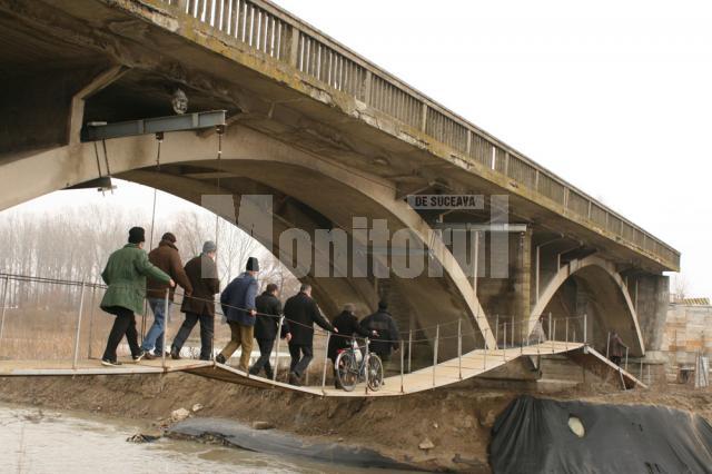 Oamenii îşi riscă viaţa zilnic trecând peste o punte improvizată