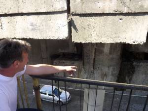 Marius Mariţan arătând spre zonele afectate ale pasarelei CFR